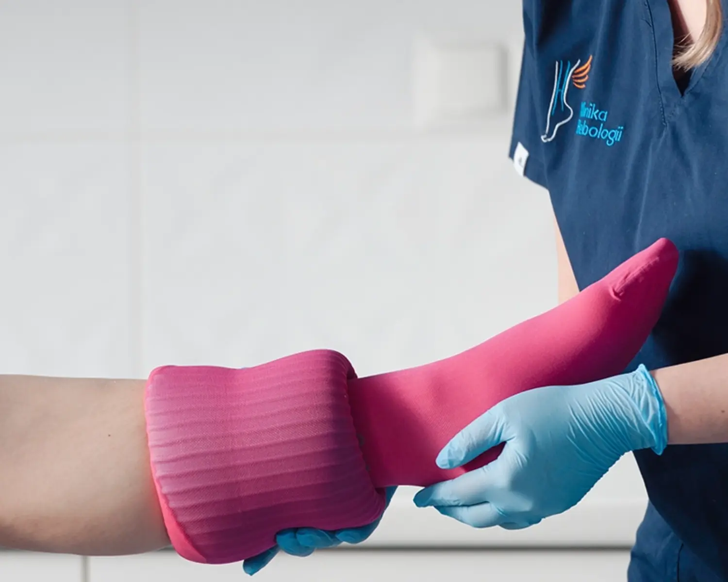 Pielęgniarka z Kliniki Flebologii zakładająca pończochę uciskową (CCL2).