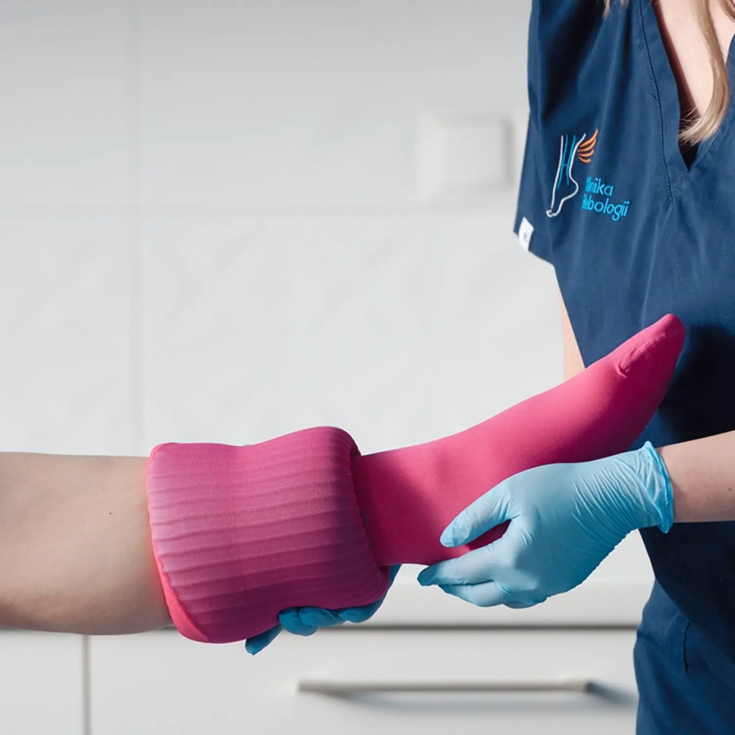 Pielęgniarka z Kliniki Flebologii zakładająca pończochę uciskową (CCL2).